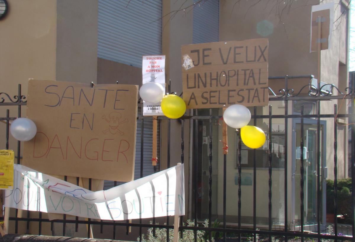 Pancartes et banderoles attachées au grillage de la sous-préfecture de Sélestat.