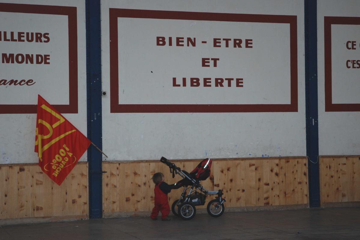 Enfant avec poussette avec drapeau LCR sous affiche bien-être et liberté