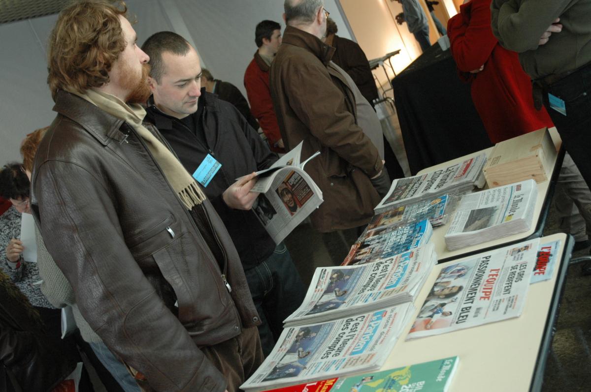 Délégués debouts devant la table de presse