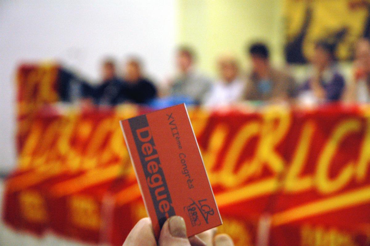 main avec mandat de délégué votant, tribune en arrière-plan