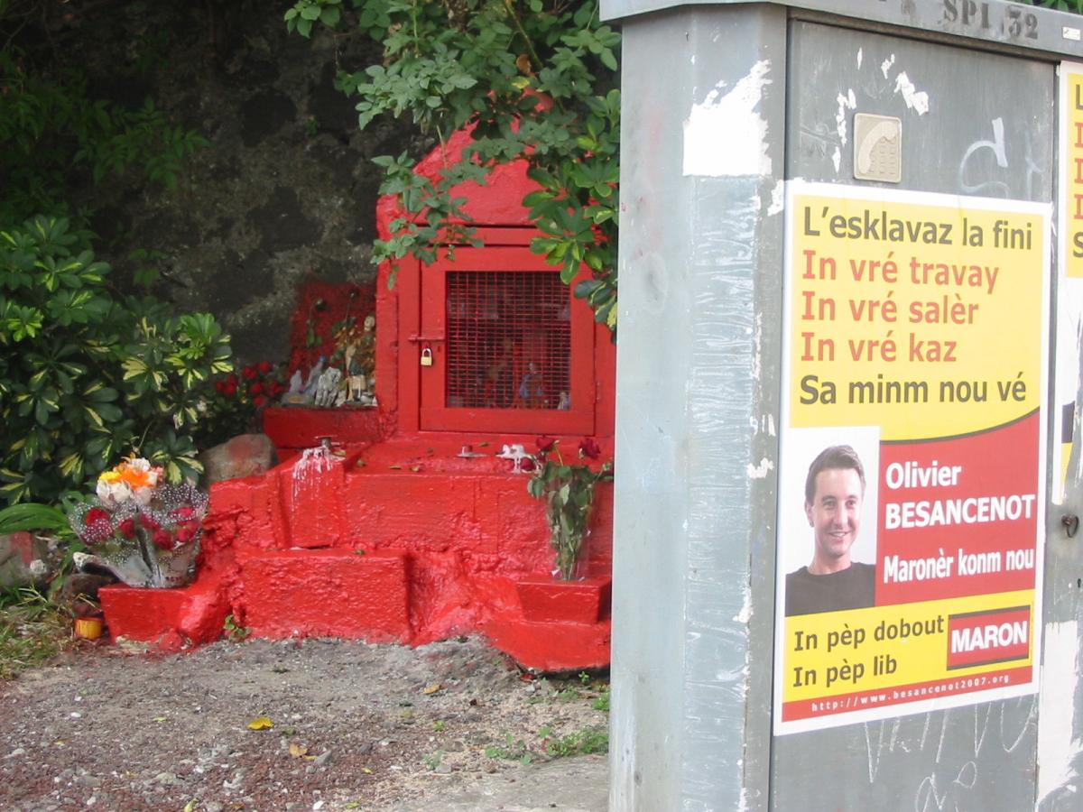 Affiche Olivier Besancenot à La Réunion devant une sépulture rouge.