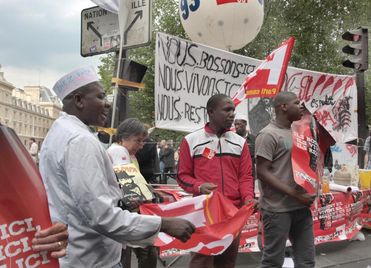 les travailleurs sans-papiers en grève font des collectes le long de la manifestation