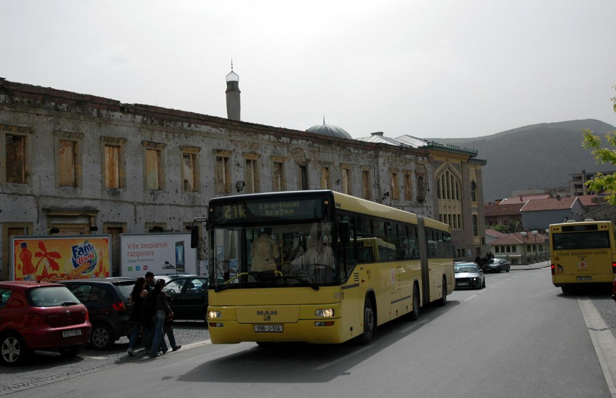 Mostar, quartier Est, bus devant un batiment en ruine.