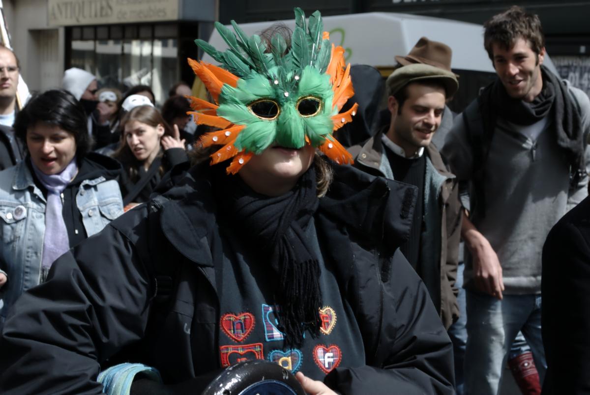 Manifestante masquée en réponse à l'interdiction de porter une cagoule dans les manifestations