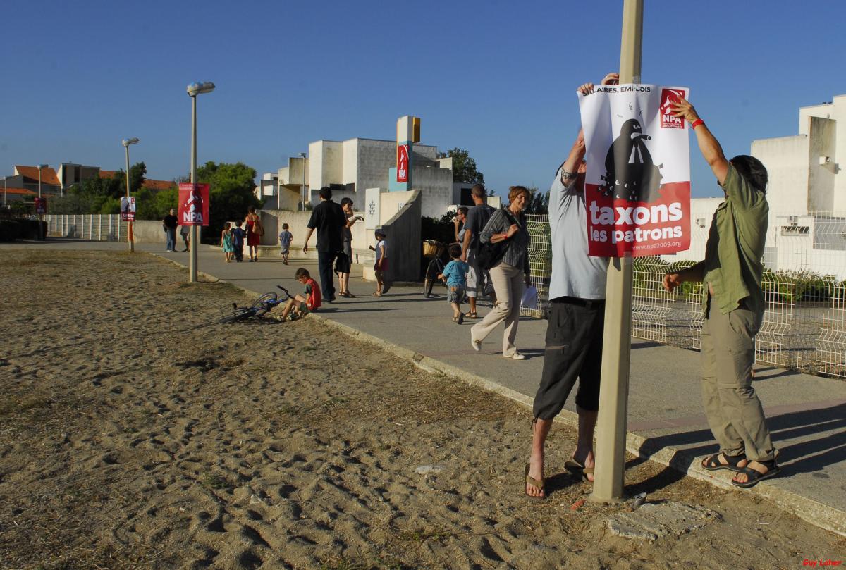 Militants installant une affiche NPA sur la plage