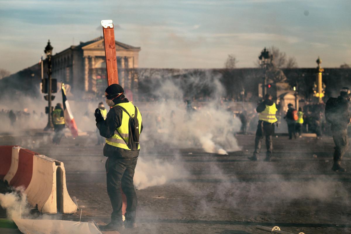 Manifestants en Gilets Jaunes parmi des lacrymos, place de la Concorde