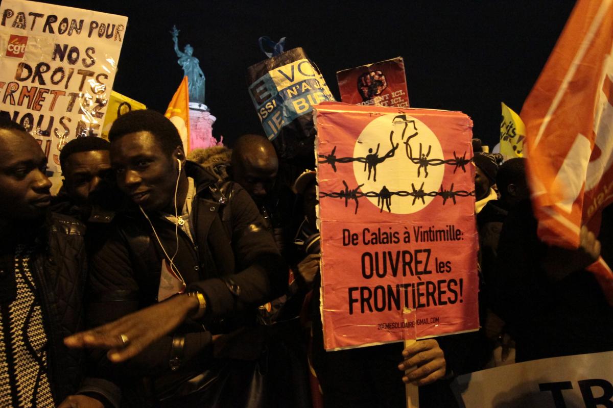 Cortège des collectifs de sans-papiers avec pancarte ouvrez les frontières