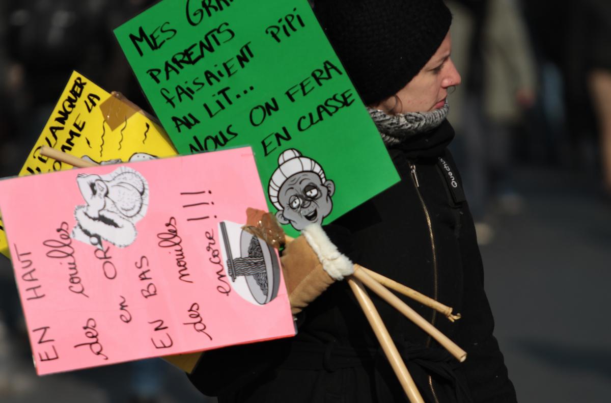 Manifestante avec 3 pancartes