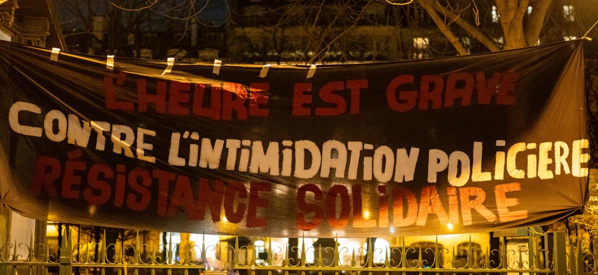 Banderole "L'heure est grave, contre l'intimidation policière, résistance solidaire